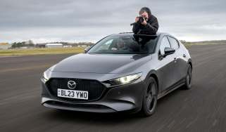 Auto Express senior photographer Pete Gibson taking photos through the Mazda 3's open sunroof
